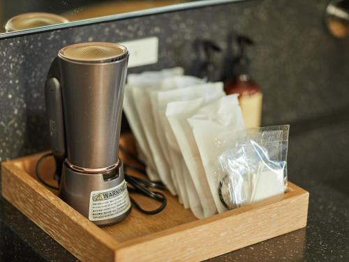 a coffee maker on a wooden tray with napkins at ANDO HOTEL NARA Wakakusayama -DLIGHT LIFE & HOTELS- in Nara