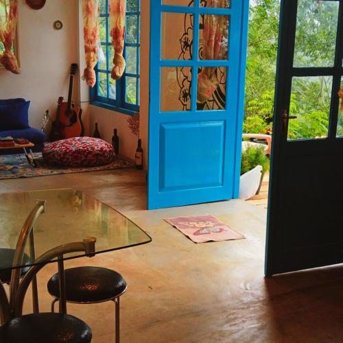 a room with a blue door and a glass table at Mountain-View Retreat Close to Ella in Badulla