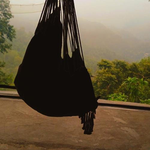 a black bird sitting in a hammock with a view at Mountain-View Retreat Close to Ella in Badulla