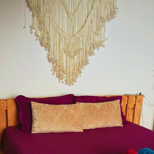 a bedroom with a purple bed with a painting on the wall at Mountain-View Retreat Close to Ella in Badulla