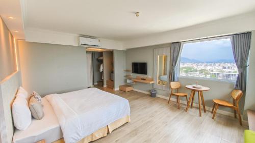 a hotel room with a bed and a window at Hua Hin Grand Hotel and Plaza - SHA Extra Plus in Hua Hin