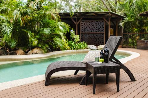 a patio with a table and chairs next to a pool at Kondalilla Eco Resort in Montville