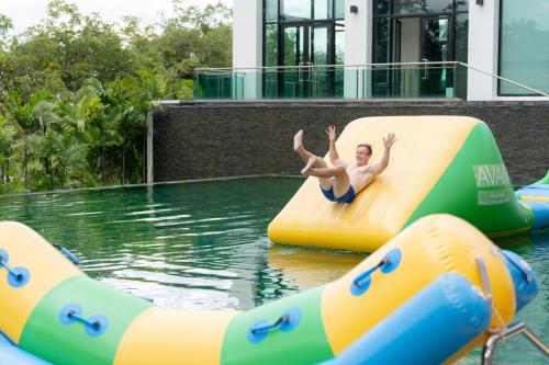 a man riding on a raft in a swimming pool at Avani Khon Kaen Hotel & Convention Centre in Khon Kaen
