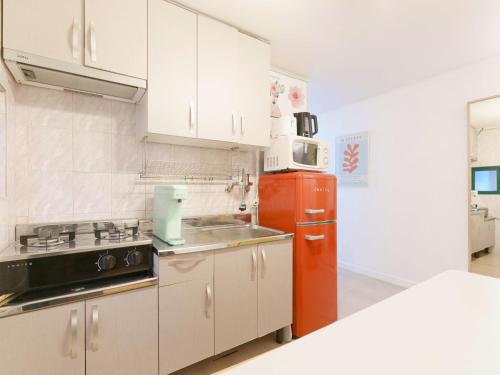 a kitchen with white cabinets and a red refrigerator at HeiStay-30sec from Hongdae SubwayStop-Elevator in Seoul