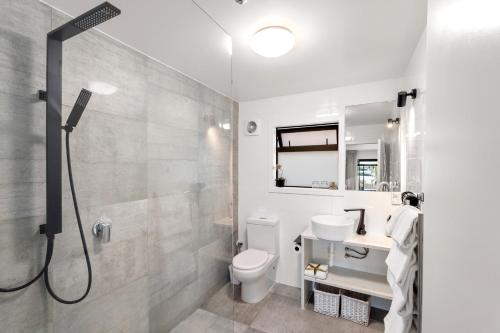 a bathroom with a shower and a toilet and a sink at Orewa Beachcomber in Orewa