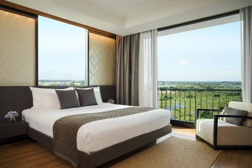 a bedroom with a bed and a large window at Avani Khon Kaen Hotel & Convention Centre in Khon Kaen