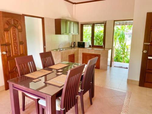 eine Küche mit Esstisch und Stühlen in der Unterkunft Villa Dua - Beachfront Sunset Garden Villa in Nathon Bay