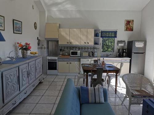 une cuisine avec une table et un canapé bleu dans l'établissement Appartement dans mas catalan avec climatisation et WiFi - FR-1-776-127, à Argelès-sur-Mer