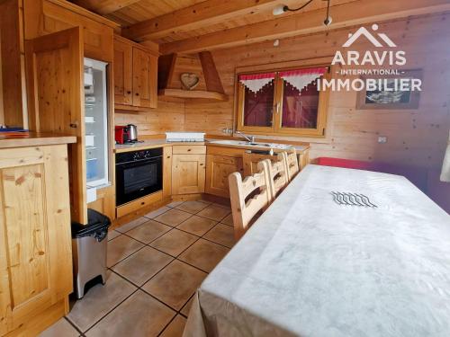 une cuisine avec une table et des chaises dans une cabine dans l'établissement Chalet mitoyen à St Jean de Sixt - 3 chambres - FR-1-391-205, à Saint-Jean-de-Sixt
