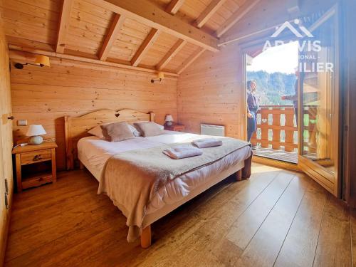 une chambre avec un lit dans une cabane en bois dans l'établissement Chalet mitoyen à St Jean de Sixt - 3 chambres - FR-1-391-205, à Saint-Jean-de-Sixt