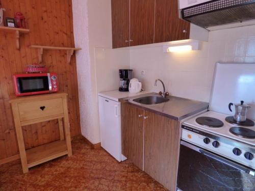 une petite cuisine avec un évier et une cuisinière dans l'établissement Studio Montagne, Balcon Sud, 4 Pers, Le Grand-Bornand - FR-1-458-215, au Grand-Bornand