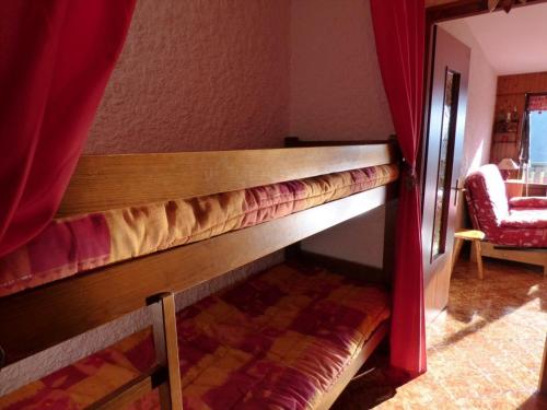 Ce lit superposé se trouve dans un dortoir doté d'un rideau rouge. dans l'établissement Studio Montagne, Balcon Sud, 4 Pers, Le Grand-Bornand - FR-1-458-215, au Grand-Bornand