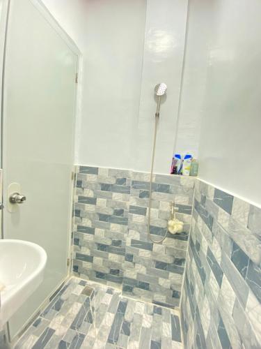 a bathroom with a shower and a sink at Arlo's Villa in Talibon