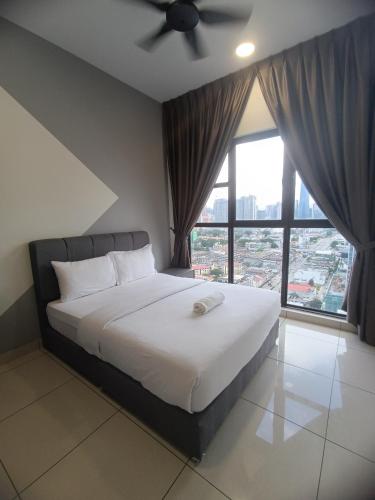 a bedroom with a white bed with a ceiling fan at Trion Residence Kuala Lumpur by Infinity in Kuala Lumpur