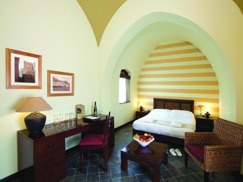 a bedroom with a bed and a desk with a desk at Radisson Blu Resort El Quseir in Quseir
