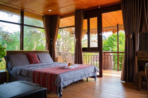 a bedroom with a bed in a room with windows at Tĩnh Lạc Viên Homestay Bảo lộc in Bao Loc