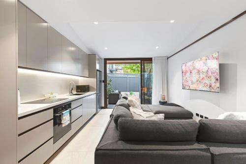 a living room with two couches and a kitchen at The Victorian Stone Terrace in Sydney