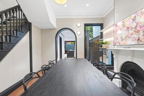 a dining room with a long table and chairs at The Victorian Stone Terrace in Sydney