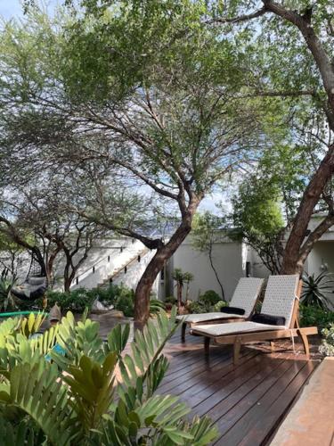 a wooden deck with two chairs and trees at Switsongo B&B in Hoedspruit