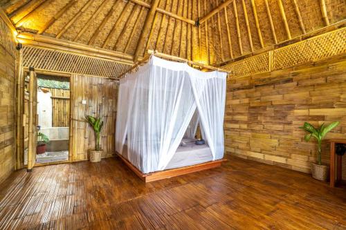 a large room with a white curtain in a building at Catappa Village Lombok in Sekotong