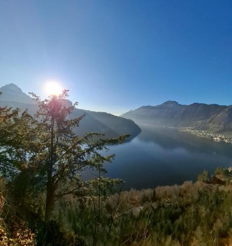 a view of a lake with the sun in the sky at Muota River Loft & Muota Industry Apartment near Stoos in Muotathal