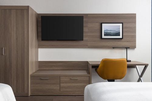 a hotel room with a desk and a television at Holiday Inn Express Montreal Airport - St-Laurent by IHG in Montréal