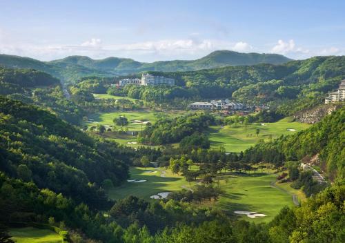 an aerial view of a golf course in the mountains at Oak Valley Resort Valley Village in Wonju