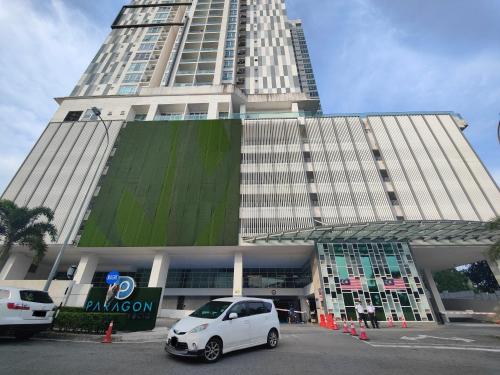 a white car parked in front of a tall building at Paragon Suites CIQ Homestay by WELCOME HOME in Johor Bahru