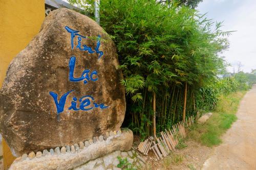 a rock with graffiti on it next to a fence at Tĩnh Lạc Viên Homestay Bảo lộc in Bao Loc