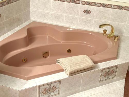 a pink bath tub with a towel in a bathroom at Spacious Room with Two Queen Sized Bed in Richmond