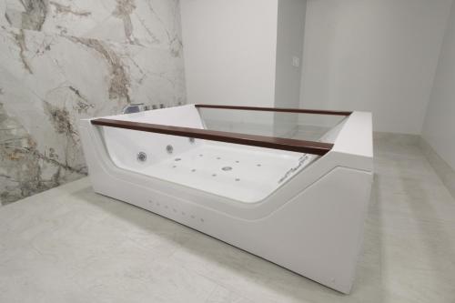 a white bath tub with a glass top in a bathroom at Envi Boutique Hotel Henderson-Evansville South in Henderson