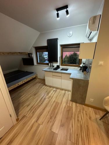 a large kitchen with wooden flooring in a house at Pokoje przy Kawiarence 2 in Rewa