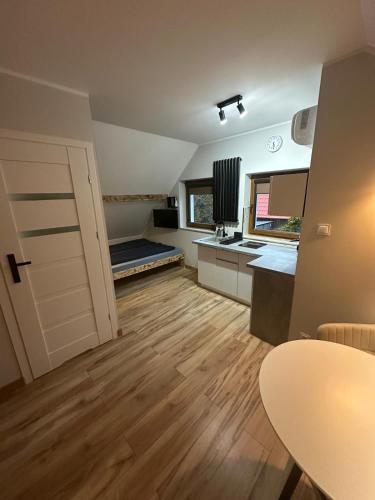 a large room with a kitchen and a door at Pokoje przy Kawiarence 2 in Rewa