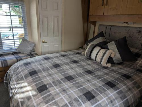 a bedroom with a bed with a checkered blanket at Otter view in Garthbeibio