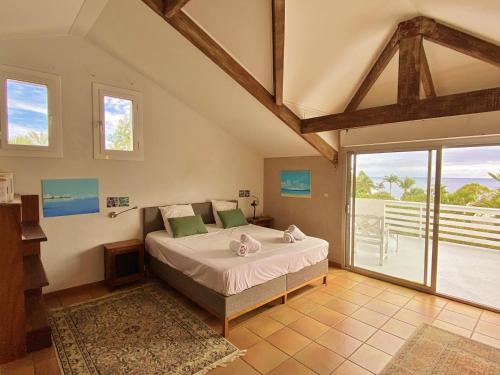 Un dormitorio con una cama y una ventana grande. en Villa Serenite, en F. Sauger