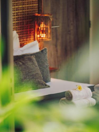 a pile of rolled towels on a table with a lamp at Domaine du Cap Sauvage in Saint-Joseph