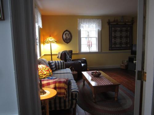 a living room with a couch and a table at Grand Oak Manor Bed and Breakfast in Granville Ferry