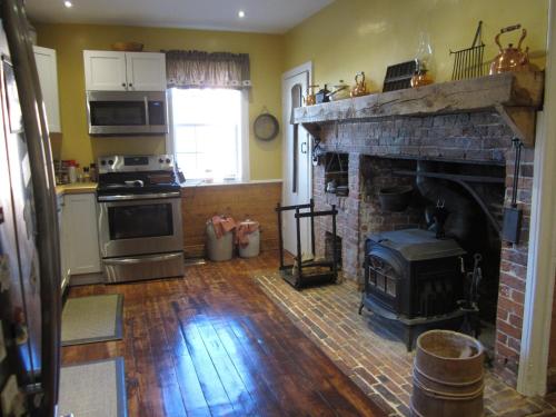 a living room with a brick fireplace in a kitchen at Grand Oak Manor Bed and Breakfast in Granville Ferry