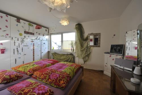 a bedroom with a bed and a desk and a window at Gästewohnung Tausendschön in Hargesheim