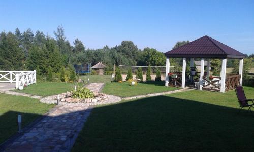 a garden with a gazebo and a grass field at Gospodarstwo Rospuda in Bakałarzewo