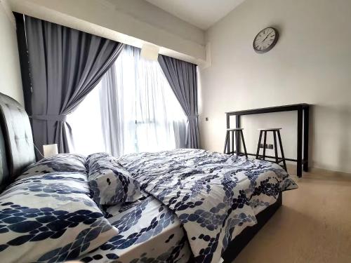 a bedroom with a bed and a clock on the wall at Star Residences KLCC in Kuala Lumpur