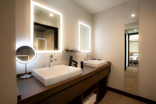 a bathroom with two sinks and a mirror at まち宿 壱龍 MACHIYADO ICHIRYU in Takayama