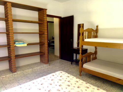 a room with two bunk beds and a bedroom at Chácara Tâmo na mió, Confortável casa de campo para famílias com Wifi, max 15 pessoas in Limeira