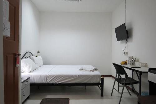 1 dormitorio con cama, escritorio y silla en Pizza Italy Restaurant and Guesthouse, en Pattaya central