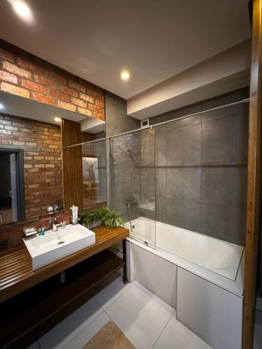 a bathroom with a sink and a shower and a tub at Bugu Hotel Bishkek in Bishkek