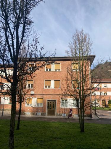 a brick building with a person walking in front of it at Apartamento en Sotrondio in Sotrondio