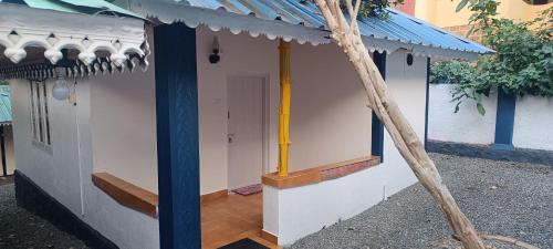 a small building with a blue roof and a door at wild campers homestay in Thekkady