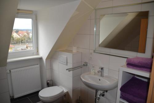 uma casa de banho com um lavatório, um WC e uma janela. em Avenzio em Wurtzburgo