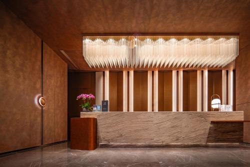 a lobby with a reception desk and a chandelier at Pullman Renhuai Chuangmeng in Zunyi