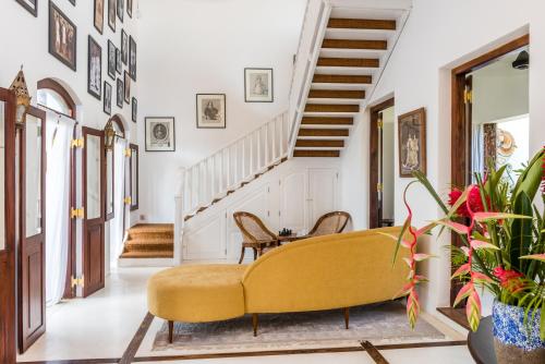 a living room with a yellow couch and stairs at Prince of Galle (inside the Fort) in Galle